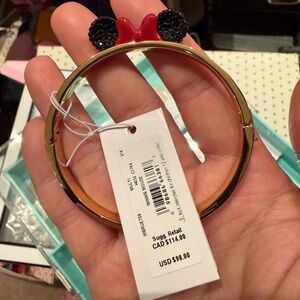 kate spade gold-tone bangle with black ear accents and red bow